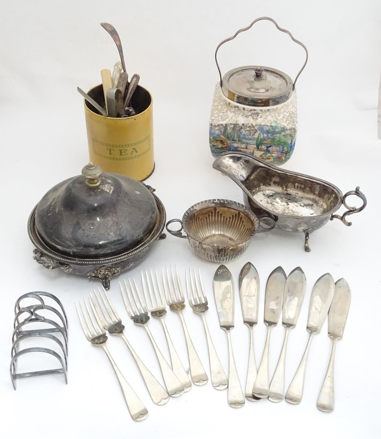 A quantity of silver plated items to include a biscuit barrel, toast rack, sauce boat, tongs, etc.