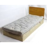 An early 20thC Heels bed, having an oak headboard above an original Heals sprung mattress and