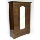 An early 20thC mahogany wardrobe with a moulded cornice above a satinwood inlayed carcass, having