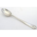 A silver teaspoon with crossed gold club and ball decoration to handle. Hallmarked Chester 1933