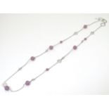 A silver necklace set with facet cut purple coloured beads. Approx. 28" long Please Note - we do not