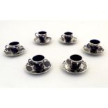 Six matched American Art Nouveau coffee cups and saucers with a blue glaze decorated with silver and