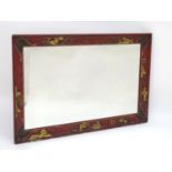 An early 20thC red lacquered Oriental style mirror with painted gilt decoration depicting stylised