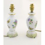 A pair of Herend pottery table lamps decorated with flowers, foliage and butterflies. Marked