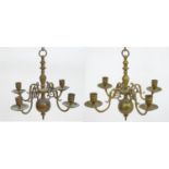 A pair of early 20thC brass candelabra, each with four lights, measuring approximately 14" wide,