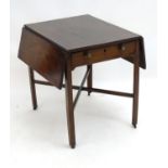 An early 19thC mahogany Pembroke table with two drop flaps to each side and having a single short