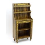 A Regency period faux coromandel waterfall bookcase with a gilt decorated frame and two shelves