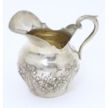 A small Continental silver cream jug with ribbon and swag decoration. Marked under 800 and with