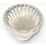 A silver butter dish of scallop shell form, hallmarked London 1900, maker George Unite. Approx. 5"
