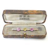 A 9ct gold brooch set with pink and yellow tourmaline. 2 1/4" long Please Note - we do not make