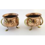 A pair of Scottish Art Nouveau copper jardinieres by Romola with three brass sinuous handles / feet.