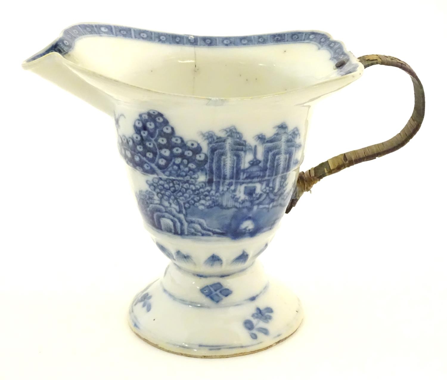 A helmet jug with blue and white decoration with a stylised landscape scene with pagodas, - Image 4 of 6