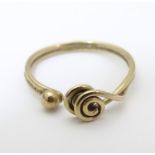 A 9ct gold ring with coiled decoration. Ring size I Please Note - we do not make reference to the