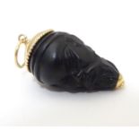 A carved pendant formed as the head of an Oriental man with lacquered finish, with 9ct gold