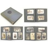 An early 20thC postcard / photograph album containing various photographs to include portraits,