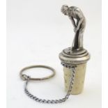 A 20thC white metal bottle stopper surmounted with a figure of a golfer, 3" tall Please Note - we do