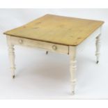 A late 19thC farmhouse kitchen table with a scrubbed pine top above a painted base, the base