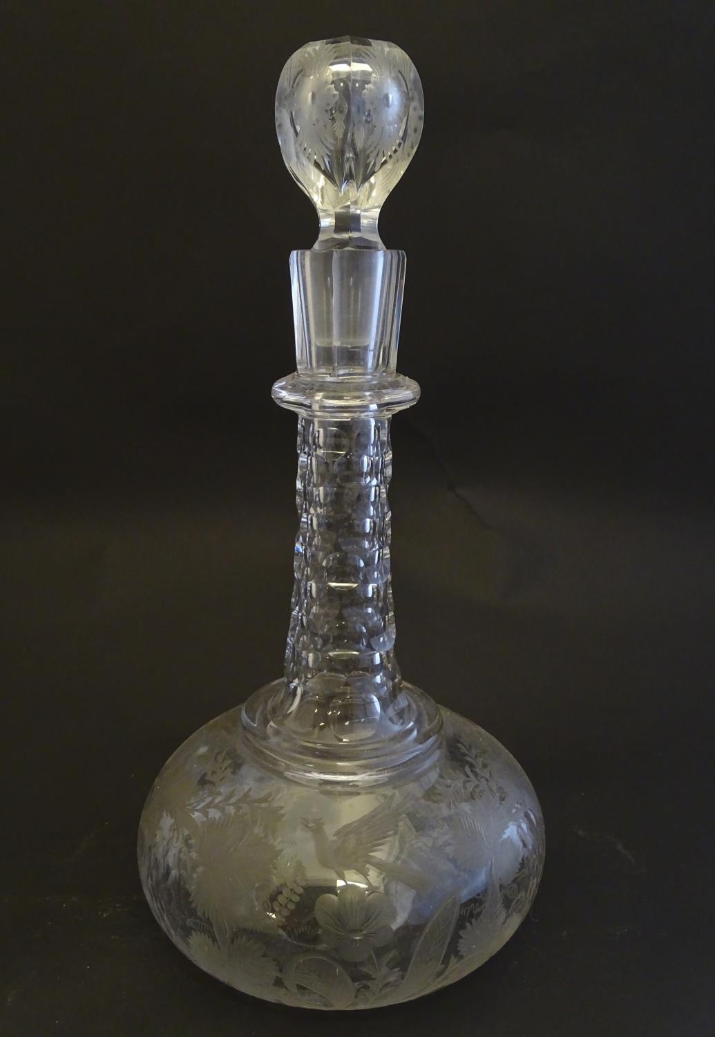 A Victorian glass onion decanter, profusely decorated with etched creeping vines, flowers, phoenix