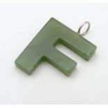 A green jade coloured pendant formed as the letter ' F ' 3/4" long Please Note - we do not make