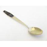A Russian silver gilt teaspoon with black enamel decoration 5 1/2" long Please Note - we do not make