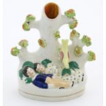 A Staffordshire pottery bud vase with two sleeping children under a tree. Approx. 5 1/4" high Please