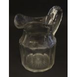 A large 19thC glass water jug , decorated with fluted oval and roundel cuts, with starburst to the