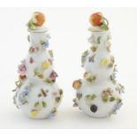A pair of Continental lidded vases decorated with insects and relief flowers, the lids topped with