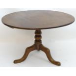 A late 19thC tilt top table with a circular one piece top above a turned stem and three cabriole