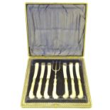 A cased set of tea knives and fork with silver pistol grip handles. Hallmarked Sheffield 1902
