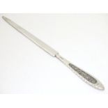 A white metal paper knife marked .830 with filigree decoration to handle. Approx. 7" long Please
