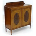 An early 20thC mahogany side cabinet with a shaped upstand, satinwood crossbanding and two doors