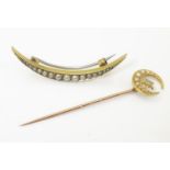 A yellow metal stick pin surmounted by crescent moon set with seed pearls and star set with diamond.