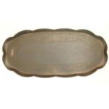 An Arts an Crafts oval copper tray with a scalloped rim and central punchwork and hammered detail.