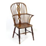 An early 19thC elm and ash double bow back Windsor chair with a pierced central splat and saddle