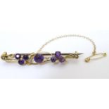 A 9ct gold bar brooch set with amethyst and seed pearls. Approx. 1 1/2" wide Please Note - we do not