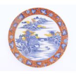 A Japanese charger depicting a mountain landscape scene with a river, boats, a bridge, pagoda