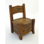 A late 19thC novelty salt box formed as a chair, constructed from beech with carved decoration,