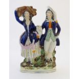 A Staffordshire pottery flat back figural group depicting a harvest couple, the man carries a flagon