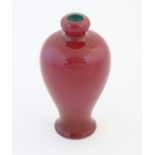 A Chinese baluster vase with a bulbous rim, with a ruby pink glaze and a turquoise interior.