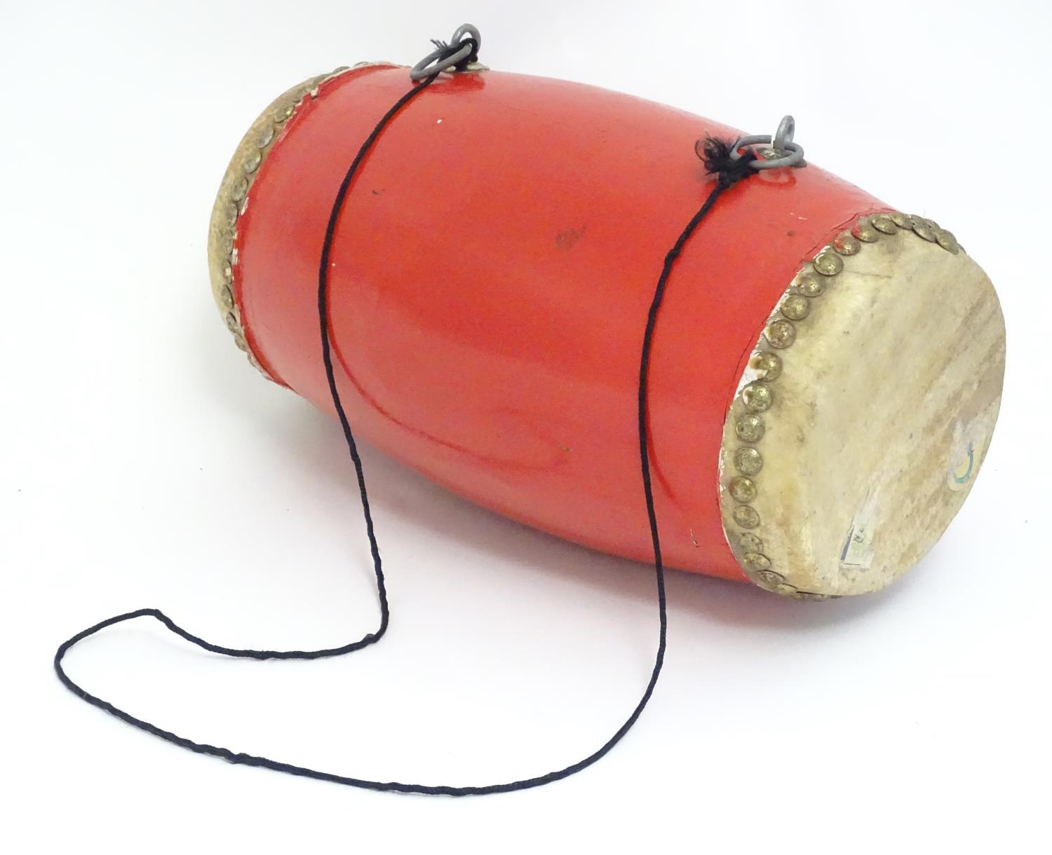 Musical Instrument: a mid 20thC Dholak drum, of elliptical form with dual skins, strap loops, in red