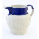 A Copeland style parian jug with a glazed cobalt blue rim, decorative in relief with hunting scenes.