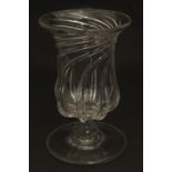 A 19thC clear glass celery vase, decorated with relief twist / swirl and standing on a wide