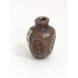 A Japanese ojime bead formed as a stylised vase with impressed detail and applied character mark