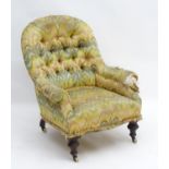 A late Victorian button back chair with sabre back legs and turned front legs terminating in