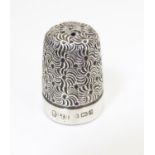 A silver thimble with engraved decoration hallmarked Birmingham 1903, maker James Swann Please