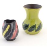 A Honiton Pottery vase with a bulbous body and flared rim with foliate decoration. Together with a