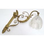 An early 20thC gilt metal wall light, the scrolling branch decorated with acanthus fronds supporting