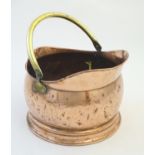 An early 20thC copper coal scuttle, of bucket form with brass swinging handle, 11 1/2" in