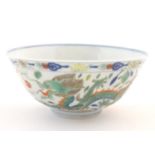 A Chinese bowl with dragon and flaming pearl detail, with flowers, foliate and stylised clouds.