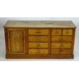 A late 19thC pine dresser base with a moulded rectangular top above a single cupboard, seven short